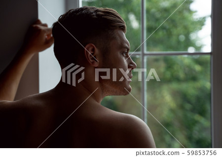 Close up of undressed man looking out the window Close up of undressed man looking out the window 59853756