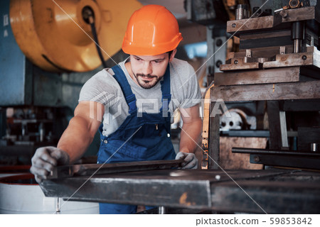 Portrait of a young worker in a hard hat at a large waste recycling factory. The engineer monitors Portrait of a young worker in a hard hat at a large waste recycling factory. The engineer monitors 59853842