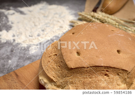 Rustic bread and wheat spikes on a grey background 59854186