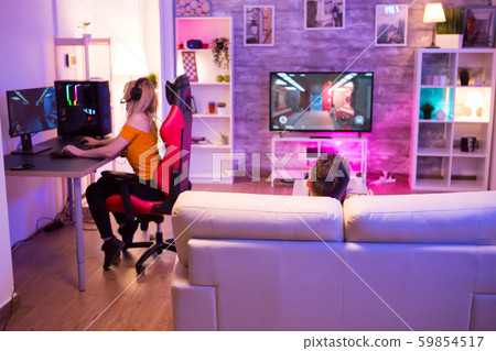 Back view of man sitting on sofa and playing games 59854517