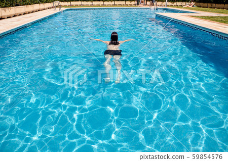 woman swimming in a pool woman swimming in a pool 59854576