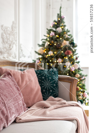 Closeup of pilows laying on sofa with decorated christmas tree on background. Selective focus 59857236