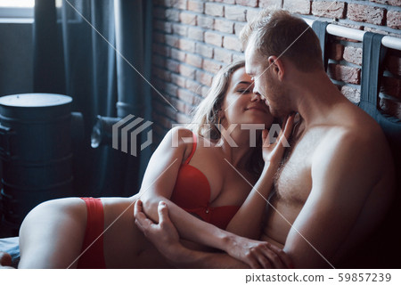 Attractive young lovers have couples playing together in bed, wearing sexy lingerie in a hotel room. 59857239