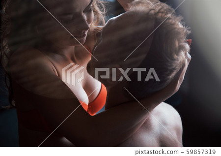 A portrait of a happy young couple who relax in a cozy bed, looking at the camera, smiles fun 59857319