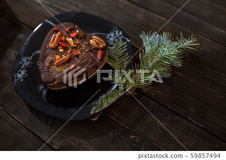 Gluten and dairy free chocolate cake with Christmas tree twig on a wooden table Gluten and dairy free chocolate cake with Christmas tree twig on a wooden table 59857494