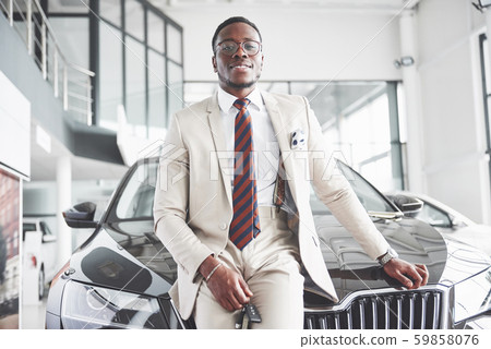 The young attractive black businessman buys a new car, dreams come true The young attractive black businessman buys a new car, dreams come true 59858076