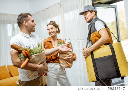 Courier delivering groceries for a couple home Courier delivering groceries for a couple home 59858347