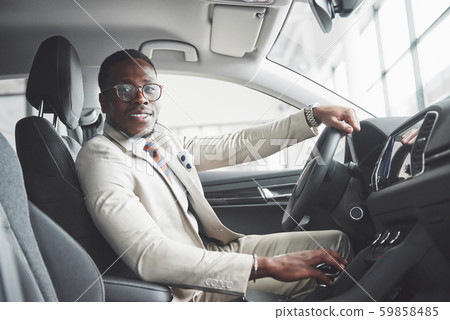 Stylish black businessman sitting behind the wheel of new luxury car. Rich african american man 59858485