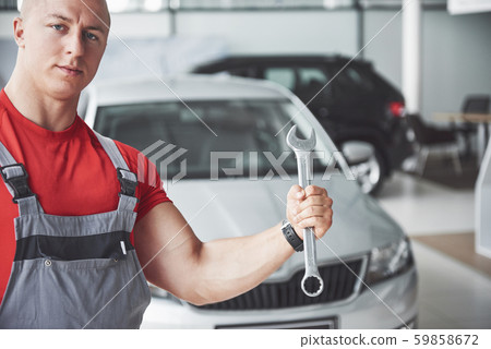 Hands of car mechanic with wrench in garage 59858672