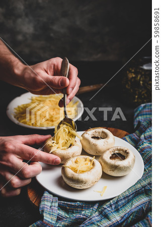 Stuffing mushrooms with grated cheese Stuffing mushrooms with grated cheese 59858691