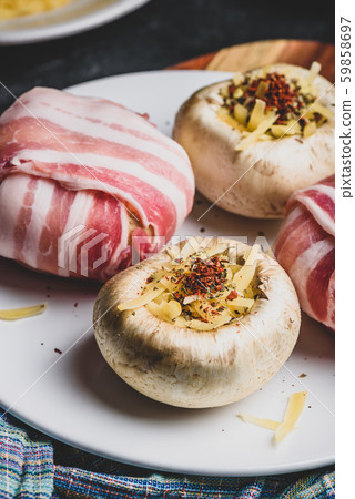 Bacon-wrapped button mushrooms stuffed with cheese Bacon-wrapped button mushrooms stuffed with cheese 59858697
