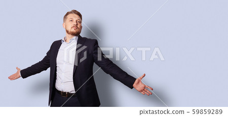 Handsome bearded man with open arms in a suit without a tie. Studio portrait over gray blue background Handsome bearded man with open arms in a suit without a tie. Studio portrait over gray blue background 59859289