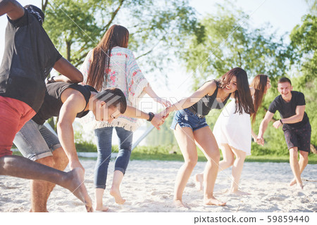 Happy friends have fun on the beach - Young people playing in open air water on summer holidays 59859440