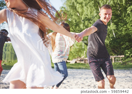 Happy friends have fun on the beach - Young people playing in open air water on summer holidays 59859442