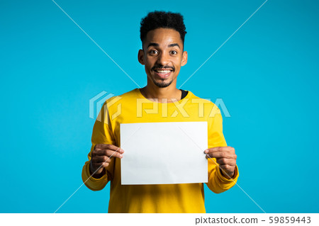 Portrait african man holding white empty paper blank on blue studio background Portrait african man holding white empty paper blank on blue studio background 59859443