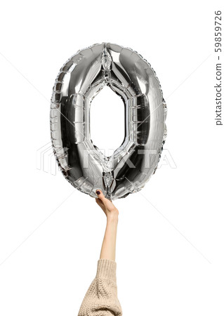Silvery inflatable figure zero in a female hand. Silvery inflatable figure zero in a female hand. 59859726