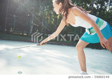 Cute girl playing tennis and posing for the camera. Cute girl playing tennis and posing for the camera. 59860149