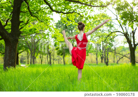 Young sports girl in a red dress practices yoga in Young sports girl in a red dress practices yoga in 59860178