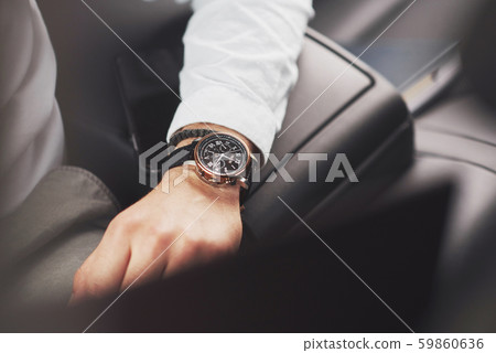 A beautiful young man is preparing to meet in full suit. 59860636