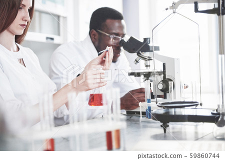 Scientists work closely with the microscope in the laboratory by conducting experiments and analyzes 59860744