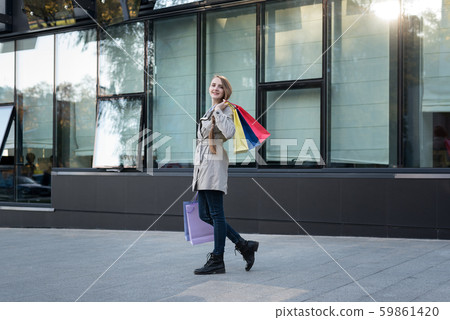 Happy young woman with colorful bags near mall. 59861420