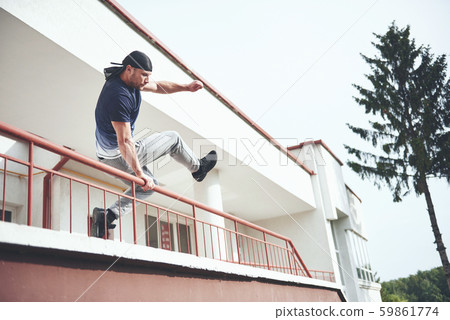 Young sports man doing parkour in the city. Young sports man doing parkour in the city. 59861774