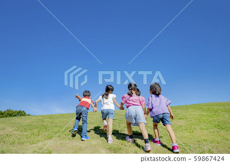 Back view of children climbing a hill in the park 59867424