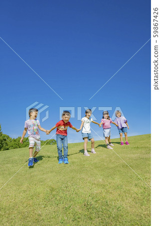 Children playing on the hill in the park Children playing on the hill in the park 59867426