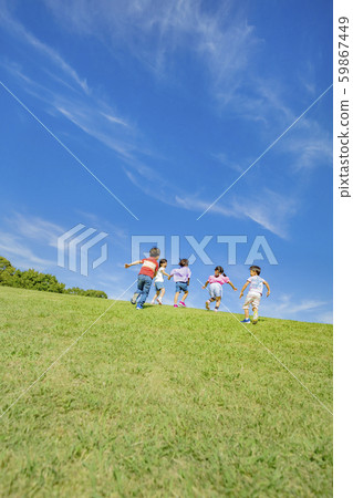 Back view of children climbing a hill in the park 59867449