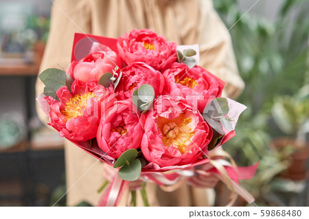 Mono bouquet of peonies, coral charm, in womans hands. Modern floral shop. Finished work of the 59868480