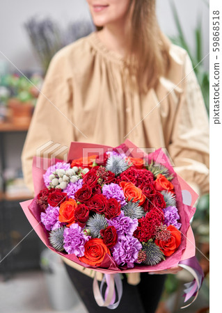 Modern floral shop. Finished work of the florist. Cute bouquet of mixed flowers in womans hands 59868518