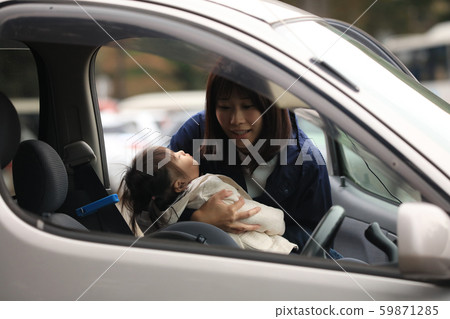 母親把睡覺的孩子放在兒童座椅上 59871285