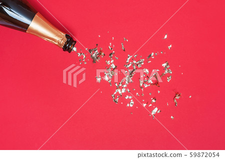Bottle of sparkling wine and gold glitter on red background, top view. Bottle of sparkling wine and gold glitter on red background, top view. 59872054