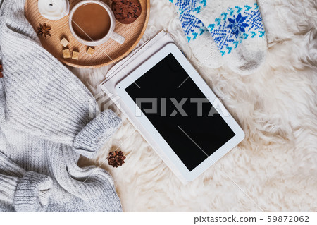 Tablet with blank screen, warm sweater and a cup of coffee on the fur Tablet with blank screen, warm sweater and a cup of coffee on the fur 59872062