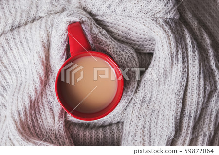Cup of coffee with milk wrapped in a warm knitted scarf or sweate 59872064