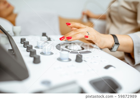 Doctor controling ultrasound machine 59872989