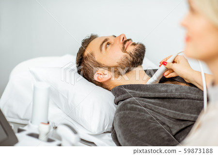 Doctor examining men's thyroid with ultrasound Doctor examining men's thyroid with ultrasound 59873188