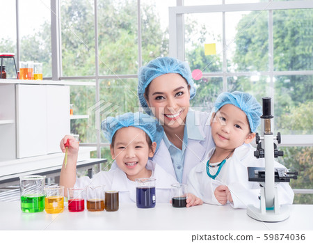 Happy beautiful teacher and two little Asian cute girl study in science lab with equipment and chemicals. 59874036