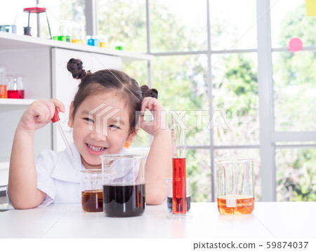 Happy Asian little cute girl role playing a scientist in science lab with equipment and chemicals. Happy Asian little cute girl role playing a scientist in science lab with equipment and chemicals. 59874037