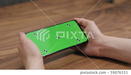 young woman holding smartphone over walnut table 59876331