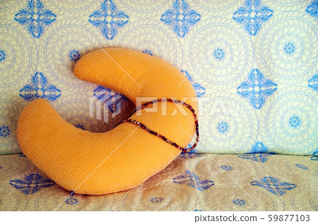Orange nursing cushion and nursing rubber placed on the sofa 59877103