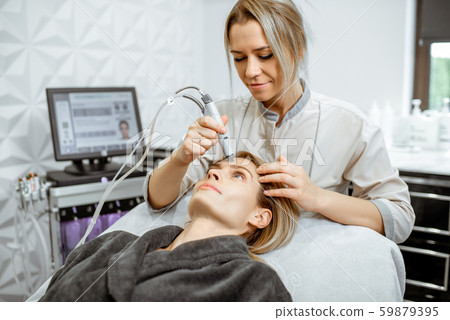 Woman making vacuum hydro peeling at the beauty salon 59879395