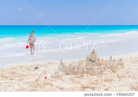 Adorable little girl playing with beach toys on white tropial beach Adorable little girl playing with beach toys on white tropial beach 59880207