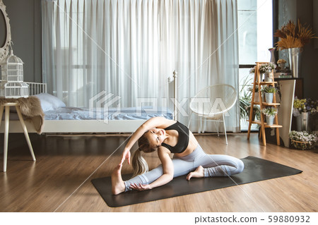 Young woman practicing yoga in gray background.Young people do yoga indoor at home. Young woman practicing yoga in gray background.Young people do yoga indoor at home. 59880932