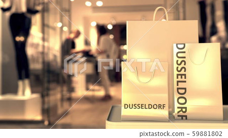 Shopping bags with Dusseldorf caption against blurred store entrance. Shopping in Germany related 59881802