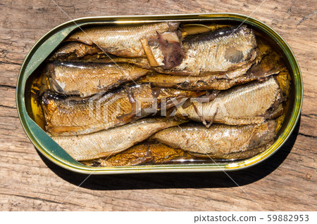 Open tin can of sprats on rustic wooden table Open tin can of sprats on rustic wooden table 59882953