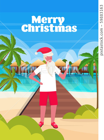 man wearing santa claus hat using smartphone on tropical beach new year christmas vacation holiday man wearing santa claus hat using smartphone on tropical beach new year christmas vacation holiday 59883163