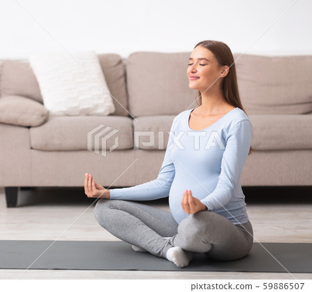 Beautiful pregnant woman doing yoga at home 59886507