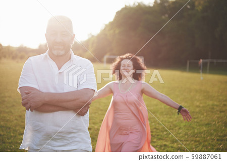 Happy old summer couple smiling at the park on a sunny day. 59887061