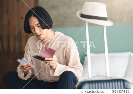 Young Asian man is sitting and checking flight 59887411